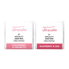 Load image into Gallery viewer, Two Ultracalm specialty soap bars in the variations &quot;Strawberry &amp; Prosecco&quot; and &quot;Raspberry &amp; Gin,&quot; both weighing 100g each and containing 50mg of CBD. The packaging is predominantly white with red accents on the labels, enhanced with natural essential oils for hydrating and nourishing effects.
