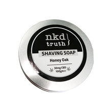 Load image into Gallery viewer, A sleek silver round metal tin container featuring an elegant black and white label reads &#39;NKD 30mg CBD Speciality Shaving Soap 100g - Honey Oak.&#39; Highlighting its luxurious Honey Oak fragrance, the premium quality ingredients include 30mg of CBD and a net weight of 100 grams.
